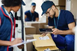 young-delivery-man-using-digital-tablet-