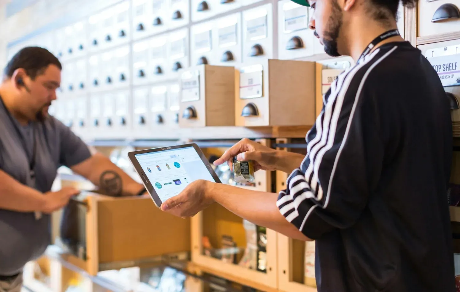 Ecommerce fulfillment workers using inventory management software while picking and packing customer orders in a warehouse.